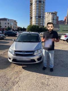 Выдача автомобиля Lada: клиент у машины (лицо скрыто, номер закрыт)