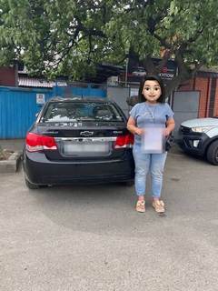 Выдача автомобиля Chevrolet: клиент у машины (лицо скрыто, номер закрыт)