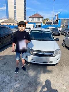 Выдача автомобиля Lada: клиент у машины (лицо скрыто, номер закрыт)