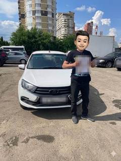 Выдача автомобиля Lada: клиент у машины (лицо скрыто, номер закрыт)
